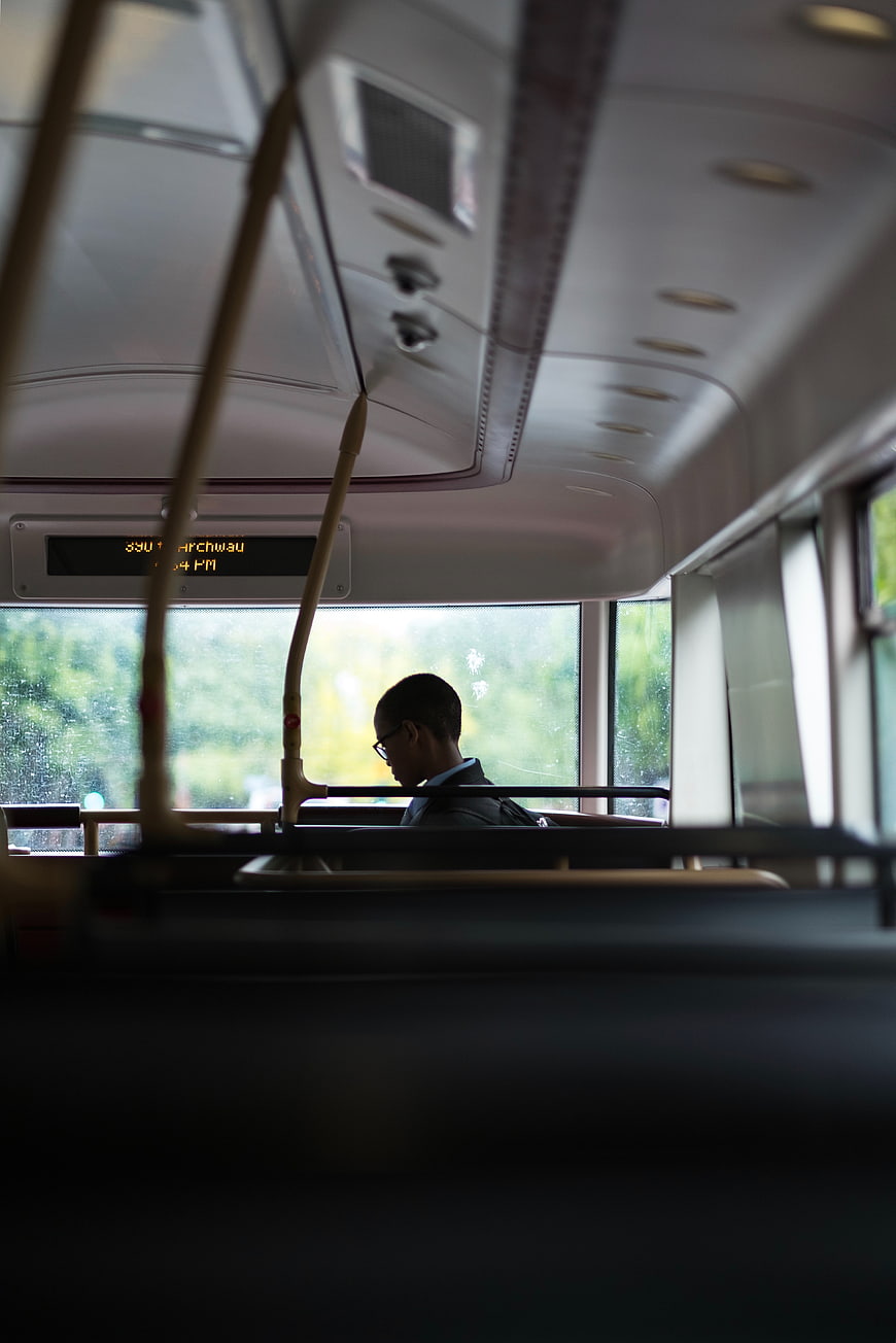Silhouette of Boy Reading on Rainy Bus Interior