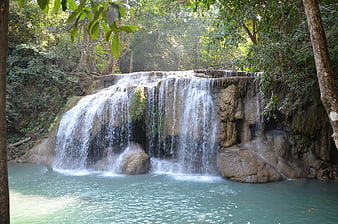 Tropical waterfall cascading into turquoise pool in lush forest