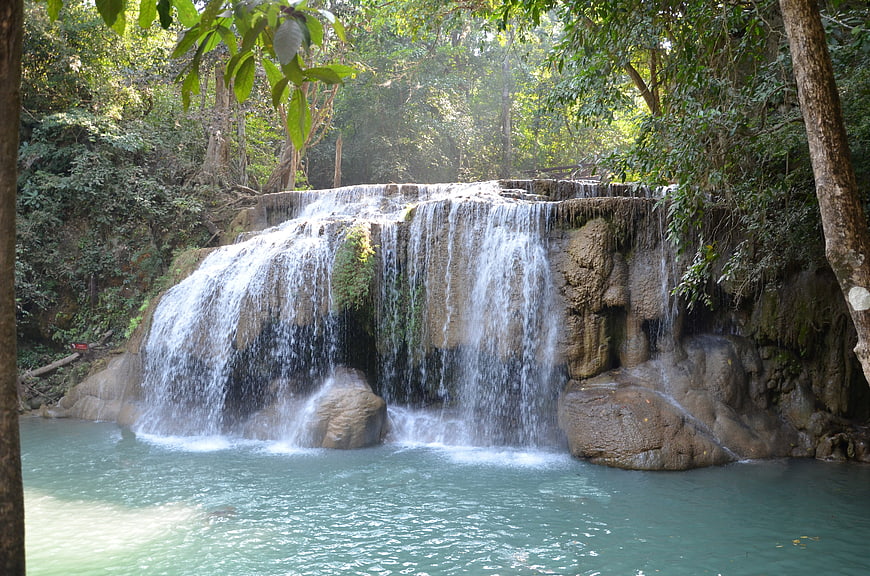 Tropical waterfall cascading into turquoise pool in lush forest