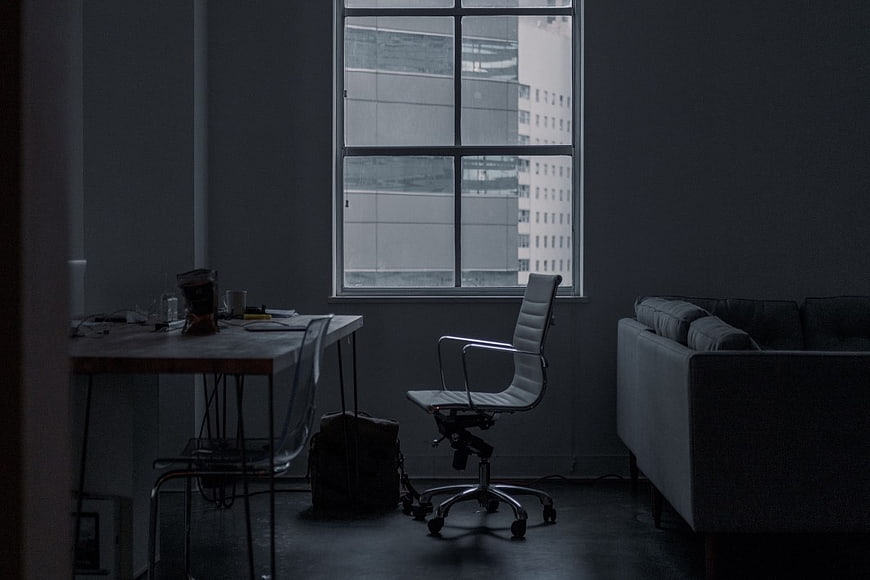 Dark Minimalist Office Interior with Desk and Window