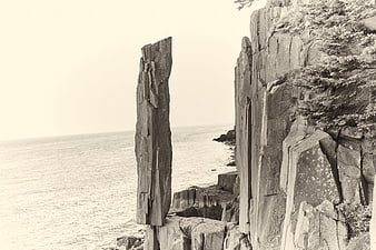 Sepia coastal cliff with vertical rock formation and ocean view
