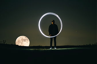 Man Silhouette with Light Painting Circle and Giant Moon