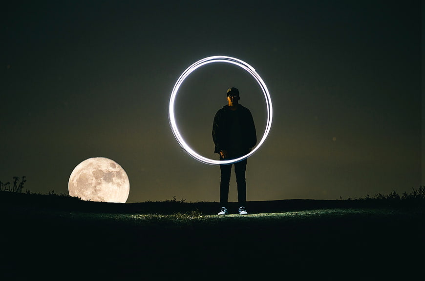 Man Silhouette with Light Painting Circle and Giant Moon