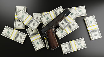 Pistol on stacks of hundred dollar bills on black background