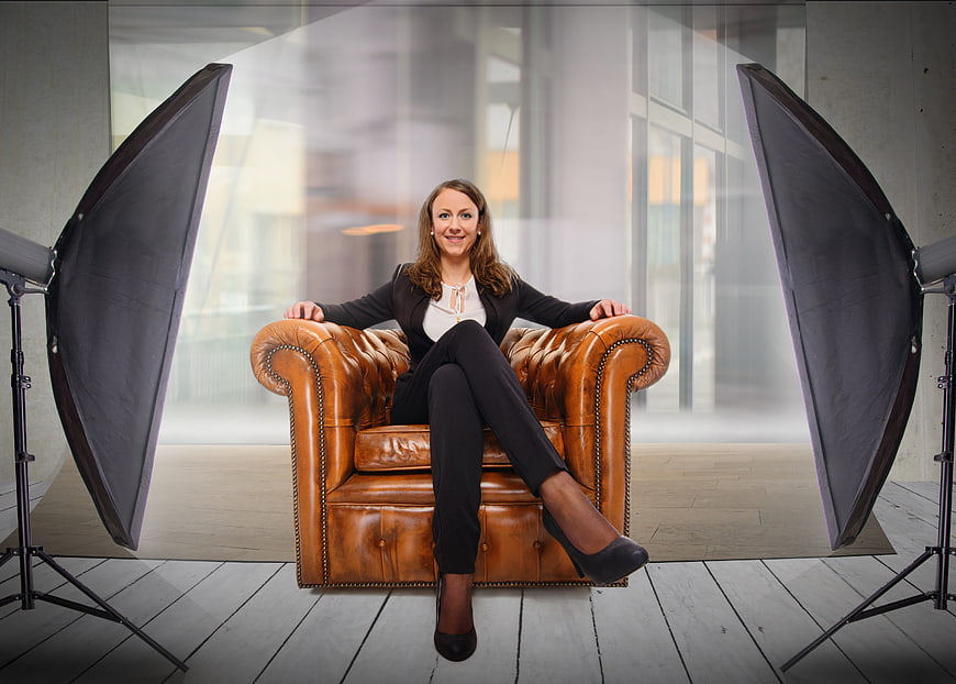 Professional businesswoman portrait in leather armchair with studio lighting