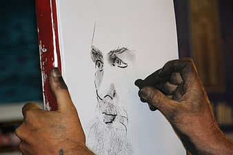 Artist Hands Creating Charcoal Portrait Sketch on White Paper