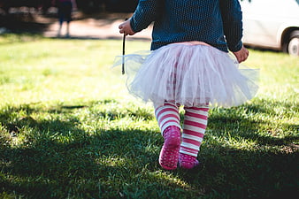 Toddler Girl Walking on Grass in Tutu and Striped Socks