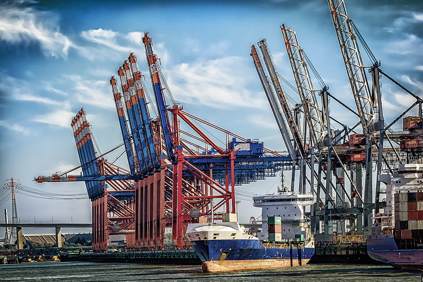 Container Ship Docked at Busy Port Terminal with Large Cranes