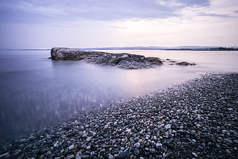 Serene Long Exposure Rocky Shoreline with Misty Water