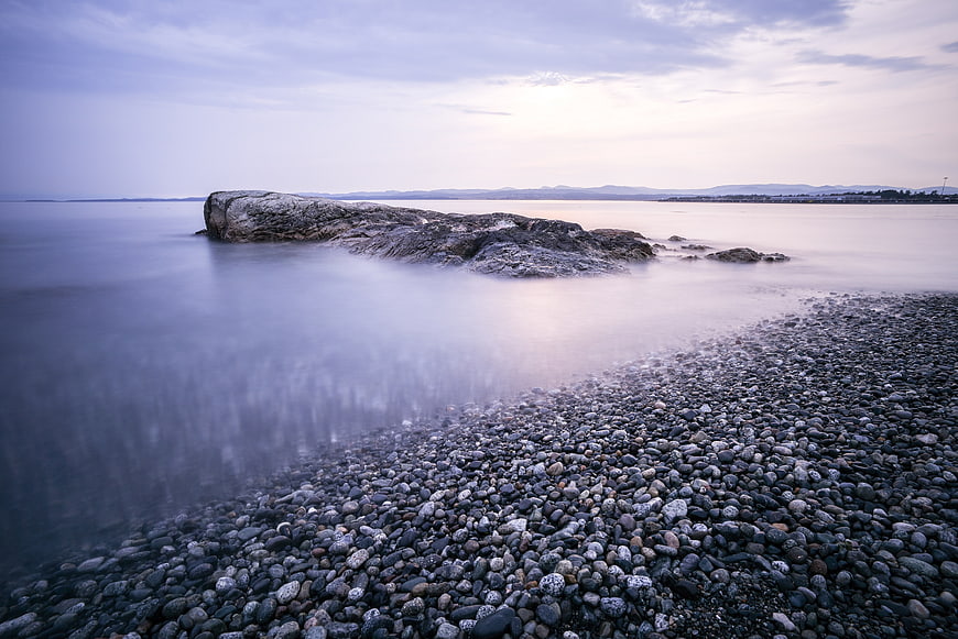 Serene Long Exposure Rocky Shoreline with Misty Water