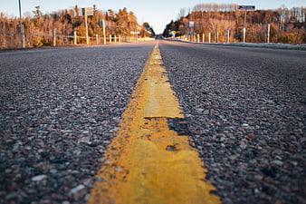 Low Angle View of Yellow Road Line on Asphalt Highway