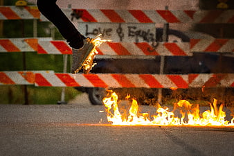 Sneaker Jumping Over Fire on Asphalt Street