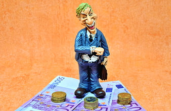 Bobblehead businessman figurine standing on euro banknotes and coins