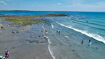Aerial View of Rocky Beach with People Swimming and Relaxing