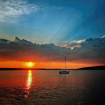 Sailboat on Lake at Sunset with Dramatic Clouds