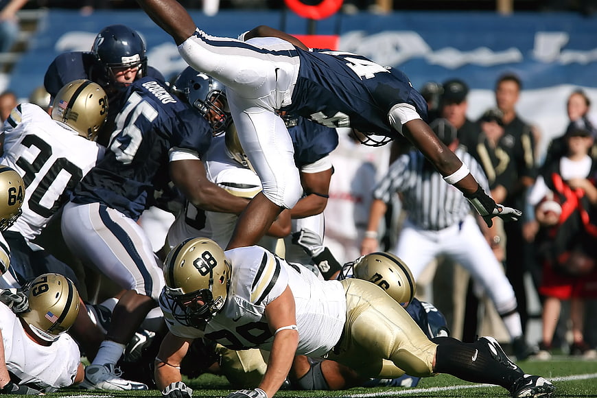 American Football Players Tackling in Mid-Air Action