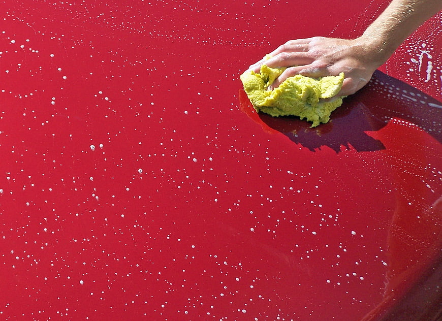 Hand Washing Red Car with Yellow Sponge