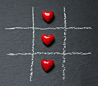 Red hearts winning tic-tac-toe game on slate