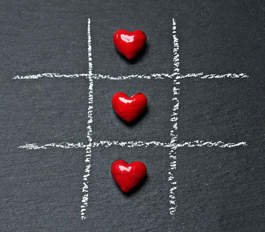 Red hearts winning tic-tac-toe game on slate