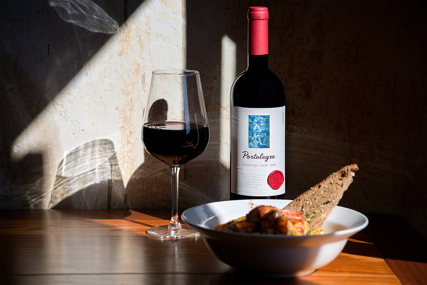 Red wine bottle and glass with rustic lunch bowl
