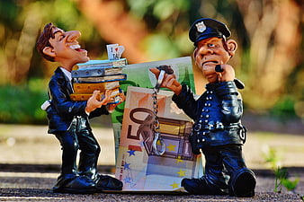 Tax Evasion Concept With Figurines, Euro Banknotes, And Handcuffs