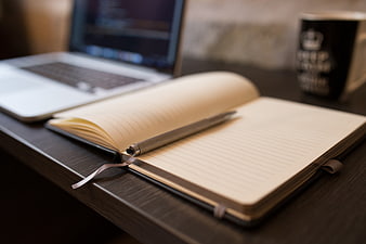 Open Notebook and Pen on Desk with Laptop