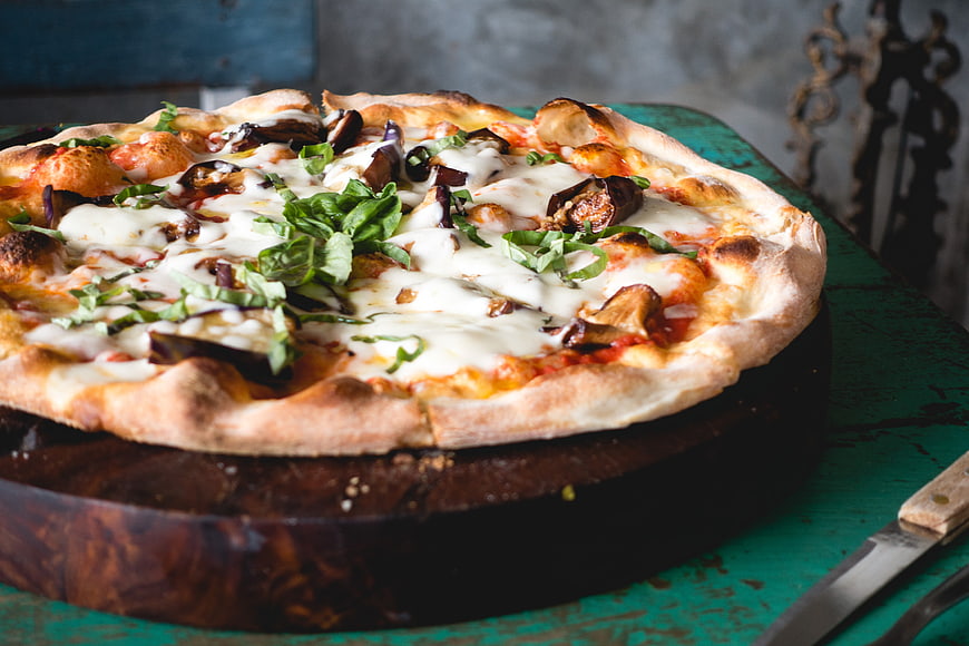 Rustic Pizza with Eggplant and Fresh Basil on Wooden Board