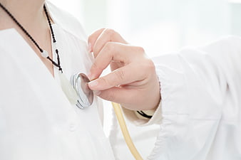 Close-up of Doctor Hand Holding Stethoscope on White Coat
