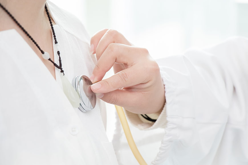 Close-up of Doctor Hand Holding Stethoscope on White Coat