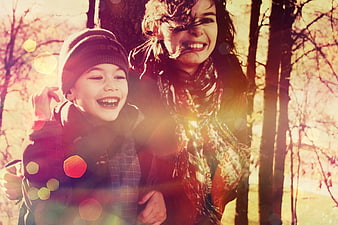 Happy Mother and Son Laughing in Autumn Forest