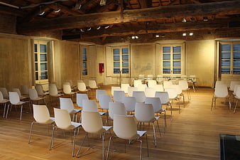 Empty Conference Room With White Chairs And Exposed Wooden Beams