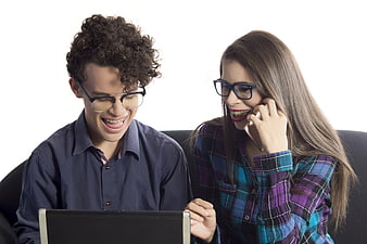Young couple with braces smiling at laptop and phone