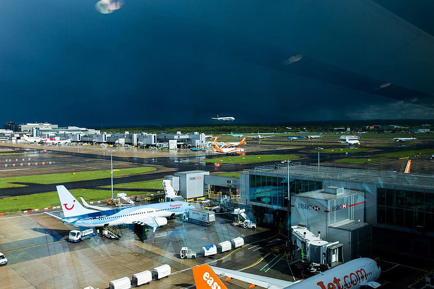 Busy Airport Terminal with Stormy Sky and Sunlight