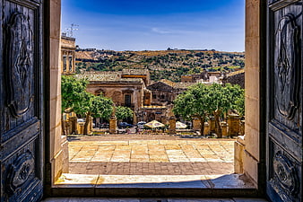 View of Modica, Sicily through open wooden church doors