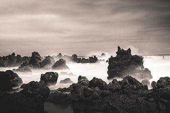 Dramatic black and white long exposure of rocky coastline