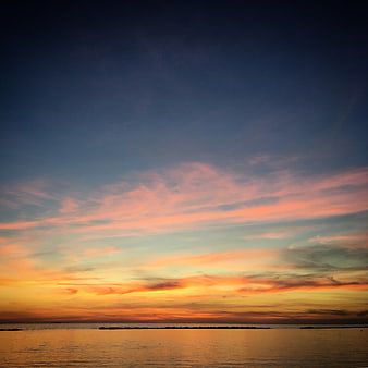 Vibrant Sunset Sky Over Calm Ocean Horizon