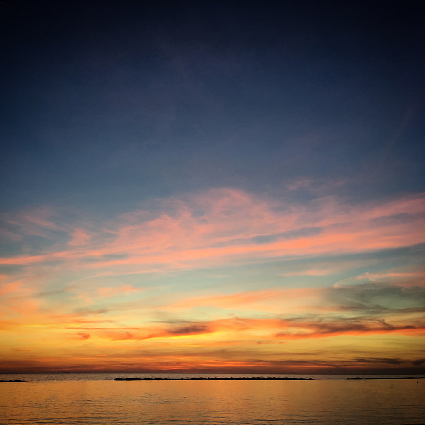 Vibrant Sunset Sky Over Calm Ocean Horizon