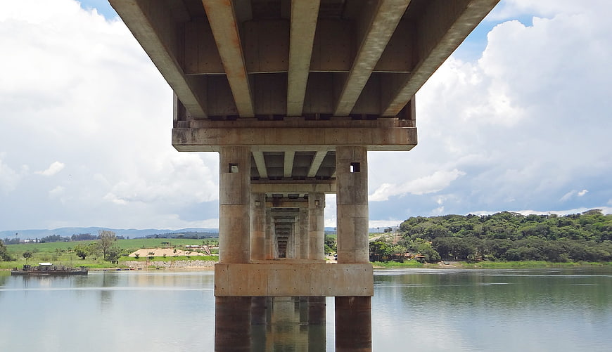 Underneath concrete bridge pillars over river landscape