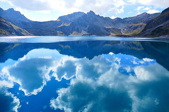 Serene Alpine Lake with Perfect Cloud Reflections and Mountains