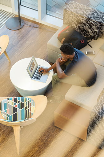 High angle view of man working on laptop in modern office lounge