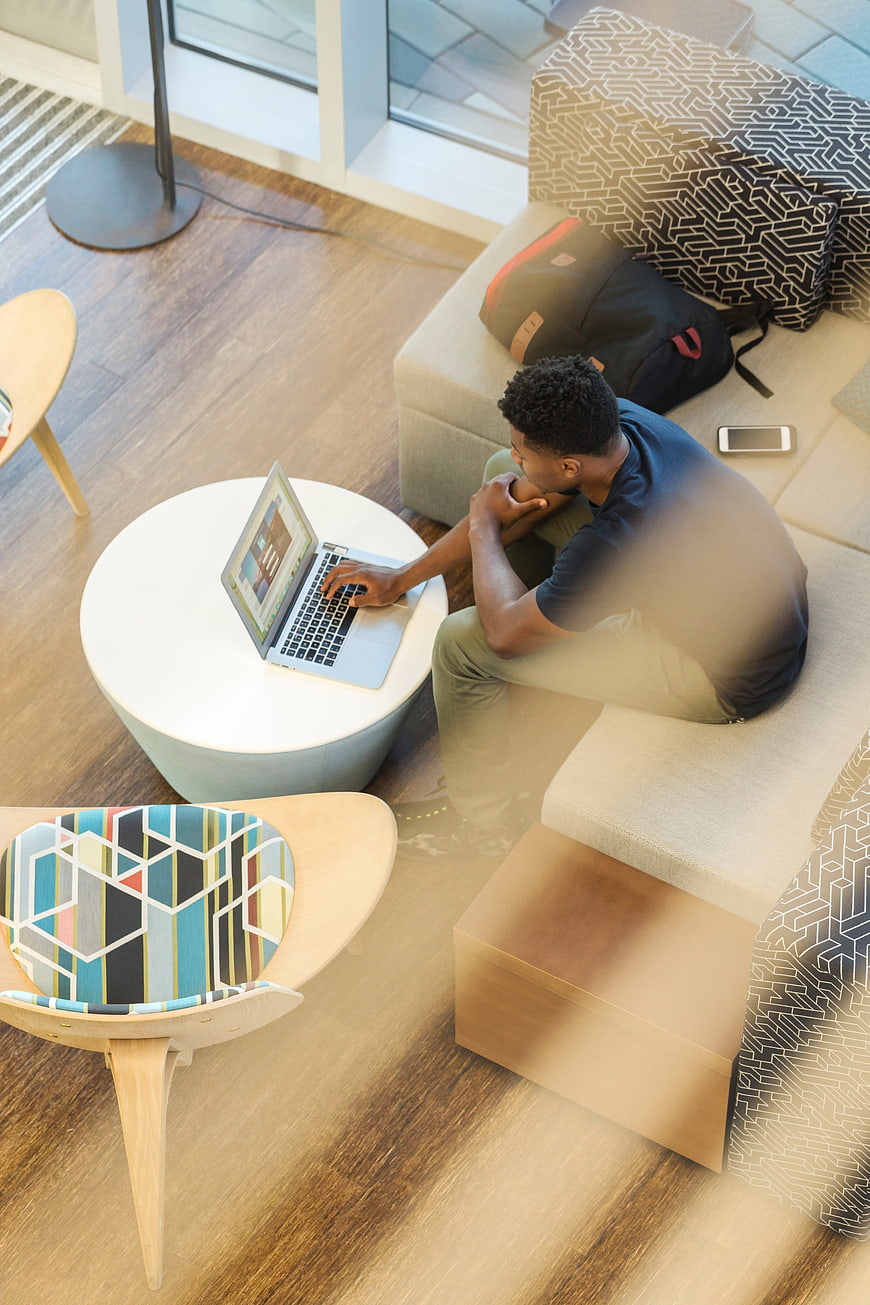 High angle view of man working on laptop in modern office lounge