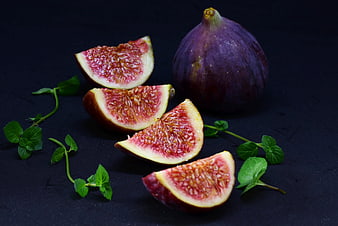 Fresh Purple Figs Cut Open With Mint Sprigs On Dark Background