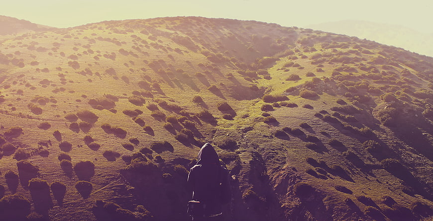 Hiker on Golden Highland Ridge at Sunset