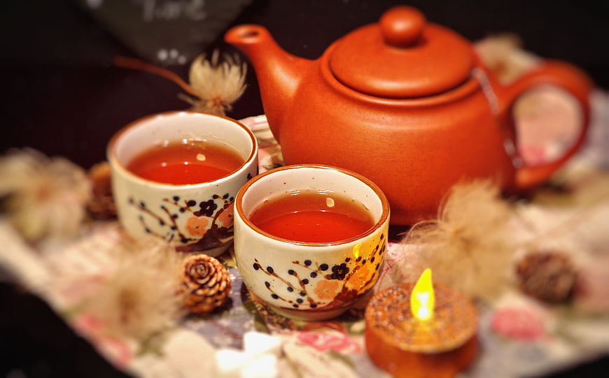 Cozy Tea Setting with Teapot, Cups, and Candle