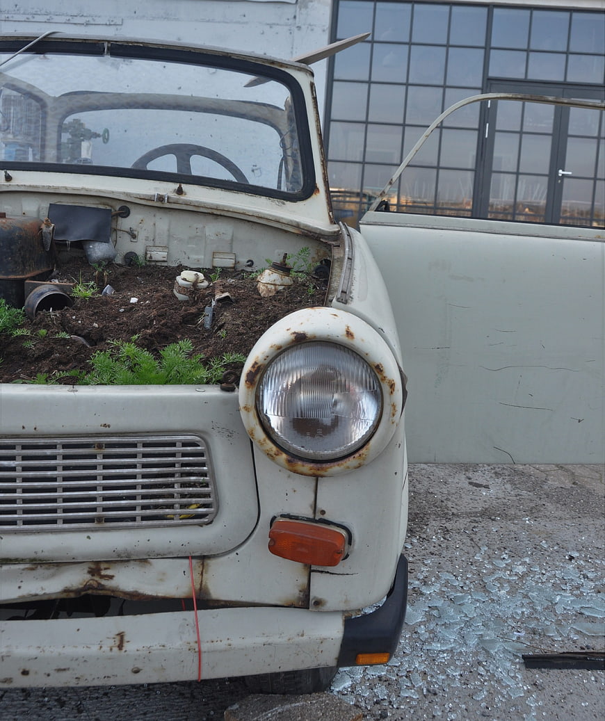 Rusty vintage Trabant car repurposed as planter