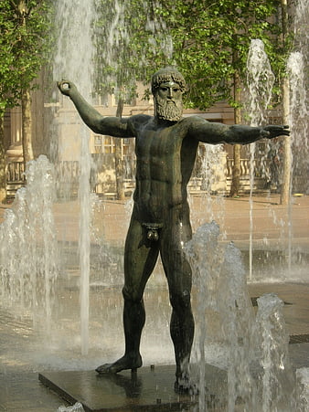 Bronze male statue in urban fountain with water jets