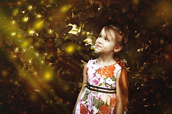 Young Girl with Red Hair Looking at Fireflies in Forest