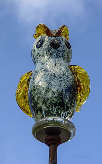 Glass Owl Sculpture Against Blue Sky