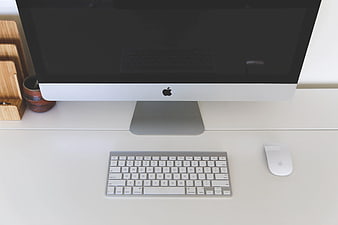 Minimalist white desk with iMac, keyboard, and mouse