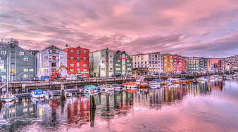 Colorful Wooden Buildings Reflected in Harbor Water at Sunset